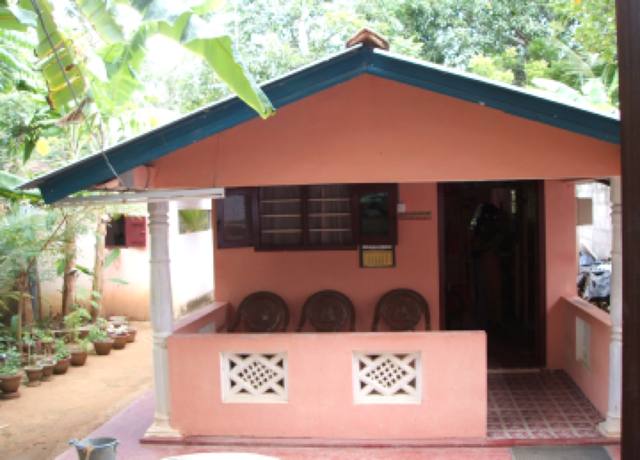 One of the nine houses built in Sri Lanka: a small single-storey home with a pink painted porch.