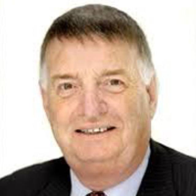 Max Crofts, smiling, in a dark suit.