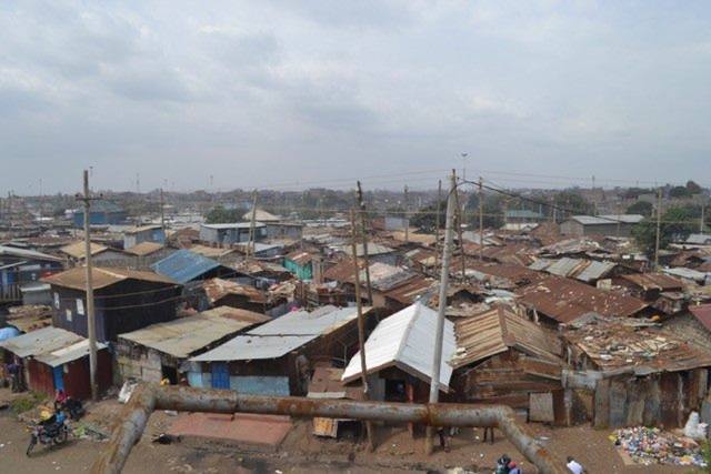 An elevated view over the packed iron-sheet roofs of the Korogocho slum.