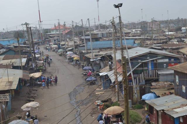 Main street: A busy main street and lots of informal stalls, sheltered from the sun by umbrellas. There are several hawkers and street sellers among our families: an informal economy and a precarious income.