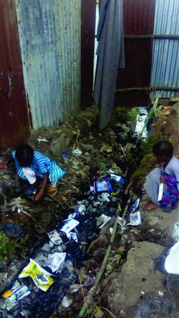 Drains: Two little girls by a drain filled with rubbish. It’s not clear whether they are playing or perhaps scavenging, as many people do for a living on the municipal dump.