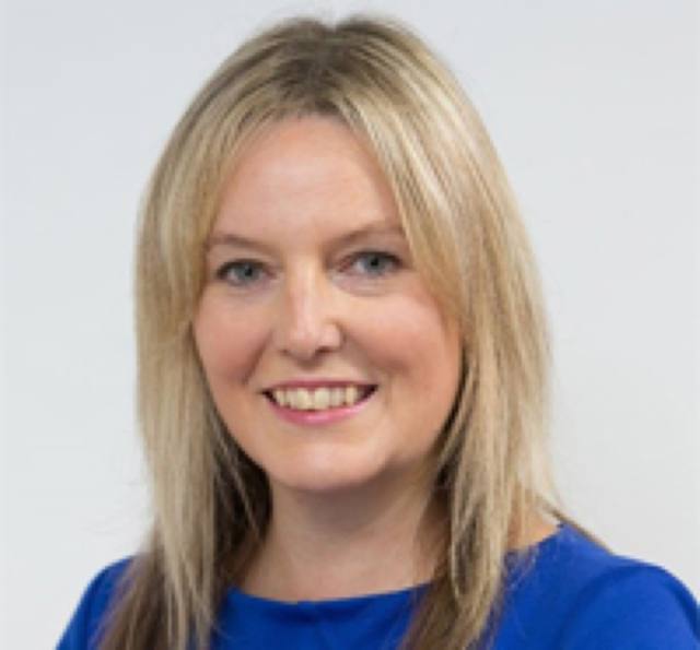 Louise Archer, smiling, in a blue top.