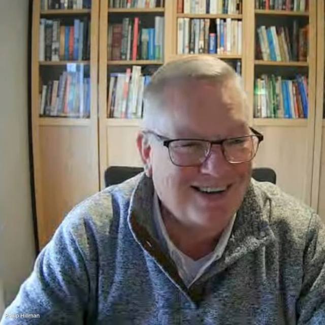 Philip Hillman smiling in front of a bookcase.